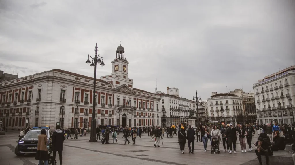 Crowds in Puerta del Sol, Madrid, with the Royal House of the Post Office clock tower