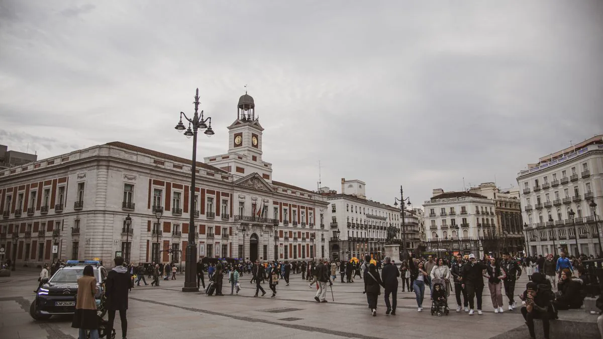 Crowds in Puerta del Sol, Madrid, with the Royal House of the Post Office clock tower